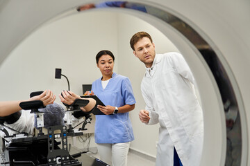 Obraz premium Healthcare professionals assisting female patient during MRI scan in a modern setting