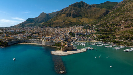 Obraz premium Aerial view of Castellammare del Golfo, a small town located in the province of Trapani, Sicily, Italy. The town overlooks the Mediterranean Sea and has mountains behind it.