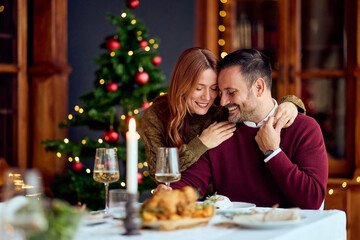 Romantic Couple At Christmas Dinner Share Warm Moment By Christmas Tree And Candlelight