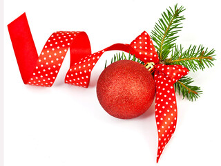 Czerwona bombka choinkowa ze wstążką w białe groszki i zielonymi gałązkami świerkowymi na białym tle