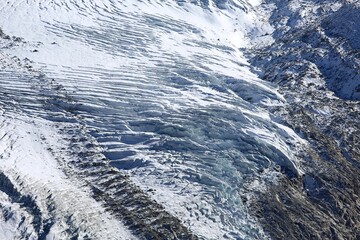 Close-up of a Swiss glacier showing ice layers, ridges, and textures &mdash; a stunning frozen alpine detail.