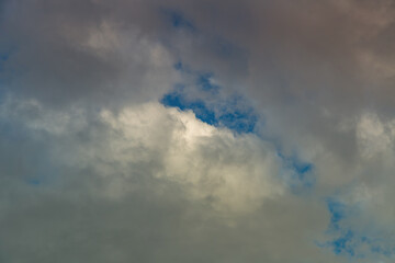 A gap among clouds revealing the blue sky.