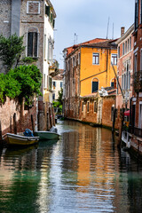 Narrow Venetian Canal with Colorful Buildings and Moored Boats