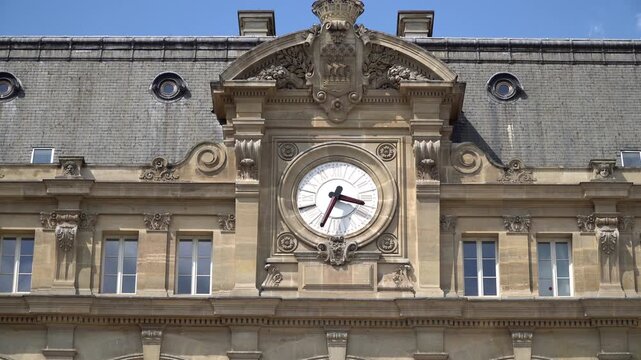 Picturesque view of vintage clock on the front facade of Saint Lazare train station building in Paris, France.