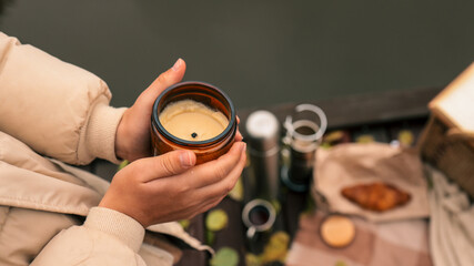 Cozy autumn picnic scene with a lit candle and warm drinks
