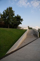 Stone walkway and green hillside under blue sky Vertical