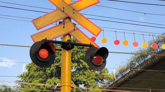 Railroad Crossing Barrie with Flashing Red Signal Lights. Signs and red warning lights at railroad crossing in Jakarta, Indonesia. 