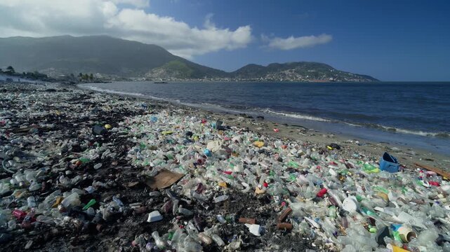 Beach covered in plastic bottles and other garbage, ocean pollution, waste management issues, and environmental damage in Haiti