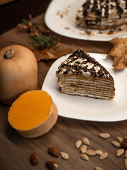 Pumpkin cake slice on a rustic wooden table. Autumn dessert.