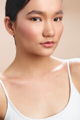 asian woman portrait in soft studio lighting with calm expression and smooth, glowing skin, conveying elegance and poise for beauty, fashion, and lifestyle projects.