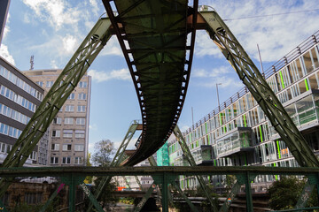 Obraz premium Monorail track curving above city street with modern buildings horizontal