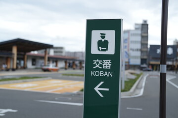 Naklejka premium A green sign with a man on it and the word Koban written in Chinese. The sign is pointing to the right
