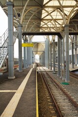 An empty train platform at Garut station showing the tracks, roof, and station facilities.