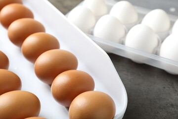 Raw chicken eggs on grey table, closeup