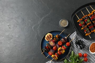 Skewers with tasty grilled vegetables served on black table, flat lay. Space for text