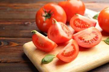 Fresh ripe tomatoes and basil on wooden table, closeup