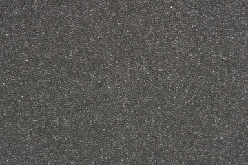 A uniform, fine-grained dark gray to black textured surface, resembling foam or sponge material