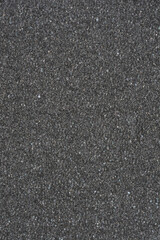 Fototapeta premium A uniform, fine-grained dark gray to black textured surface, resembling foam or sponge material