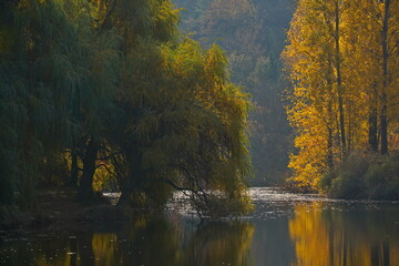 Fototapeta premium Soldier Lake. A lake in a mountainous area with different vegetation. Bright juicy autumn leaves, leaf fall and reflection in the water.