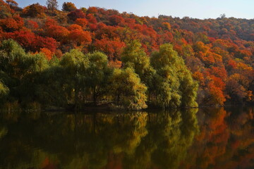 Obraz premium Soldier Lake. A lake in a mountainous area with different vegetation. Bright juicy autumn leaves, leaf fall and reflection in the water.