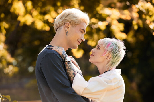 Young couple shares a joyful moment in a sunlit park surrounded by autumn colors