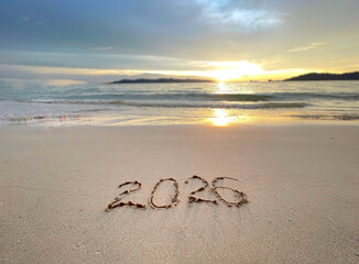 2026 written on the beach sand with a beautiful sunset view. New Year concept.