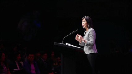 Confident Female School Principal Delivering Inspiring Speech from Podium at Educational Conference