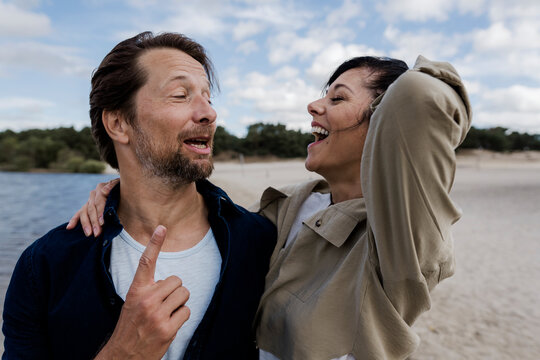 Couple laughing and singing together outside in nature on windy day