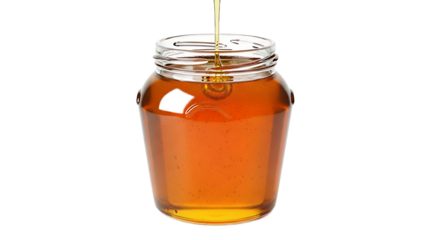 Golden honey pouring into a transparent glass jar on a black background