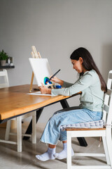 Female kid painting a rainbow at home- Education, art and creativity for children concept - Main focus on face - Vertical video