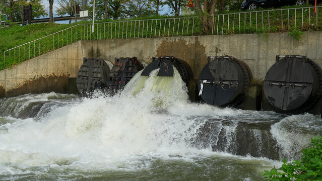 Powerful water flow through floodgate drainage system in urban infrastructure