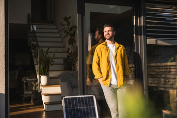 Smiling freelancer standing next to solar panel