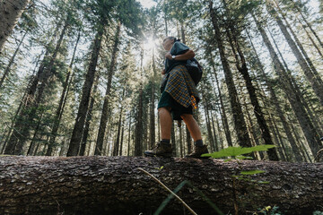 Hiker woman balancing on fallen tree trunk in forest © olezzo