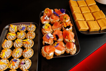Assorted canapes with salmon, cream cheese and edible flowers