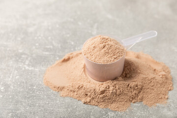 Protein powder. A spoonful of protein powder on a table. Different flavors of whey protein powder. Sports nutrition concept. Gym. Amino acid food supplement, creatine powder. Copy space.