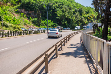 Sunny street with hillside view. Urban living, nature integration, and relaxed Mediterranean...