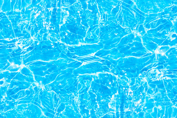 Blue water with ripples on the surface. Defocus blurred transparent blue colored clear calm water surface texture with splashes and bubbles. Water waves with shining pattern texture background.