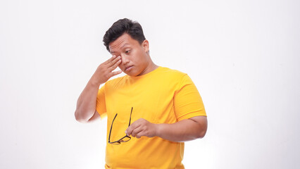 Young Asian fat man suffering from strong eye pain. Healthcare concept on white background