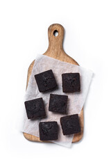 Homemade chocolate brownies on cutting board isolated on white background