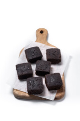 Homemade chocolate brownies on cutting board isolated on white background