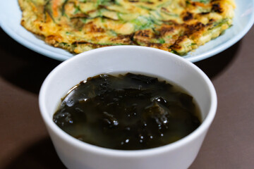 Korean seaweed soup against a Korean pancake