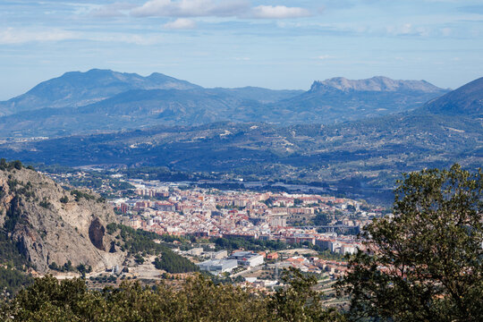 Vista panor&aacute;mica de la ciudad de Alcoy en el valle, flanqueada por la Sierra de la Safor y la Sierra de Mond&uacute;ver en el horizonte monta&ntilde;oso, Espa&ntilde;a
