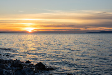 Obraz premium Sunset over calm lake with golden reflections