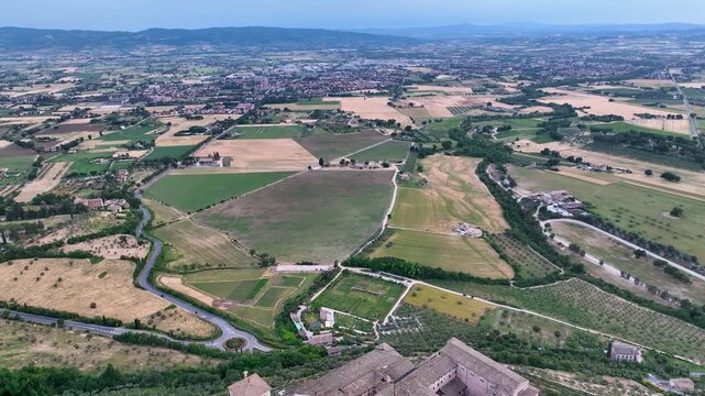 Aerial view of the Basilica of Saint Francis, showcasing the architectural marvel amid the lush green landscape of Assisi, Umbria, Italy.