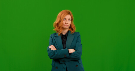 Annoyed bored young woman standing and crossing her hands impatient. Half body isolated on green...