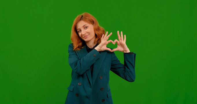 A woman is demonstrating various gestures, showcasing her creativity and confidence while posing in front of a green background in a studio setting. - Powered by Adobe
