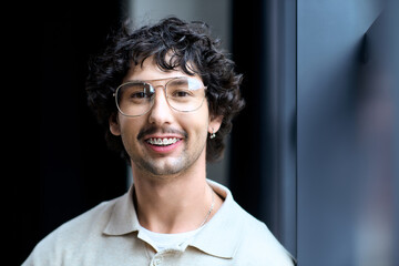 Fototapeta premium Charming young man smiling confidently in modern indoor setting