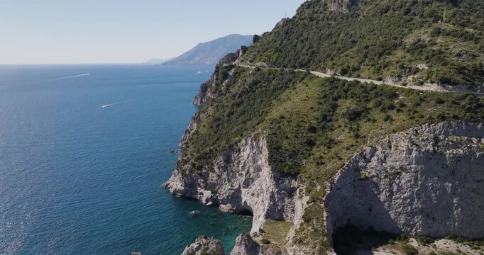Aerial view of the Amalfi Coast road winding along the dramatic cliffs, contrasting with the blue sea, Erchie, Amalfi Coast, Italy.