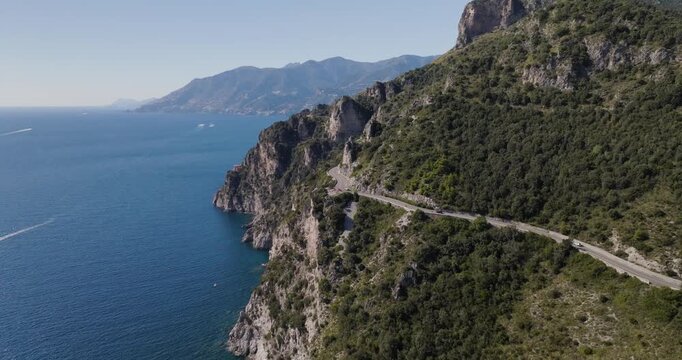 Aerial view of the rugged coastline, where steep cliffs meet the azure sea, a winding road snakes along the mountainside, Erchie, Amalfi Coast, Italy.