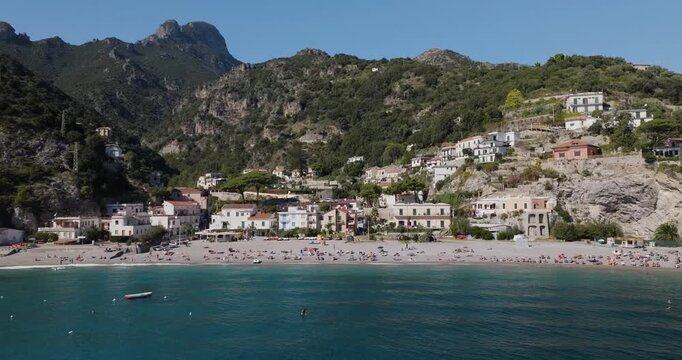 Aerial view of Erchie beach, where the turquoise sea meets the sandy shore, nestled beneath mountains and buildings, Erchie, Amalfi Coast, Italy.